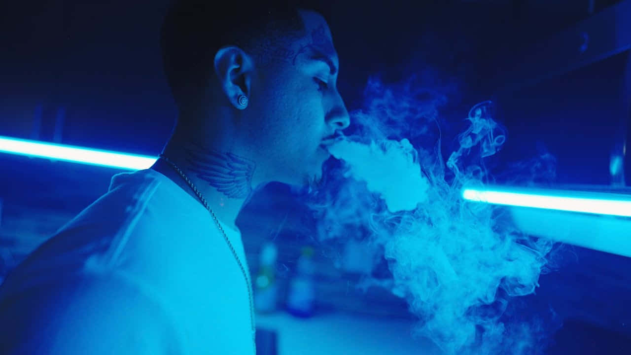 Man Exhaling Smoke Under Blue Lights Wallpaper