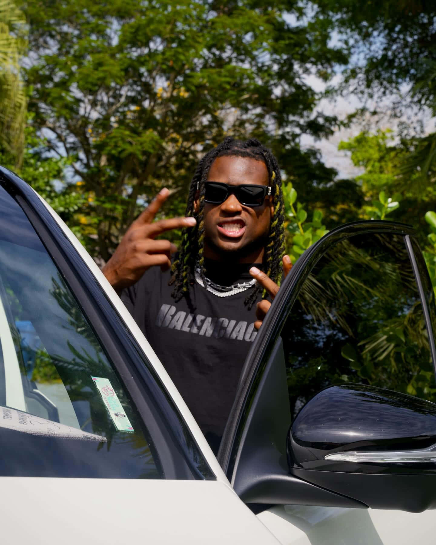 Man Gesturing Peace Beside Car Wallpaper