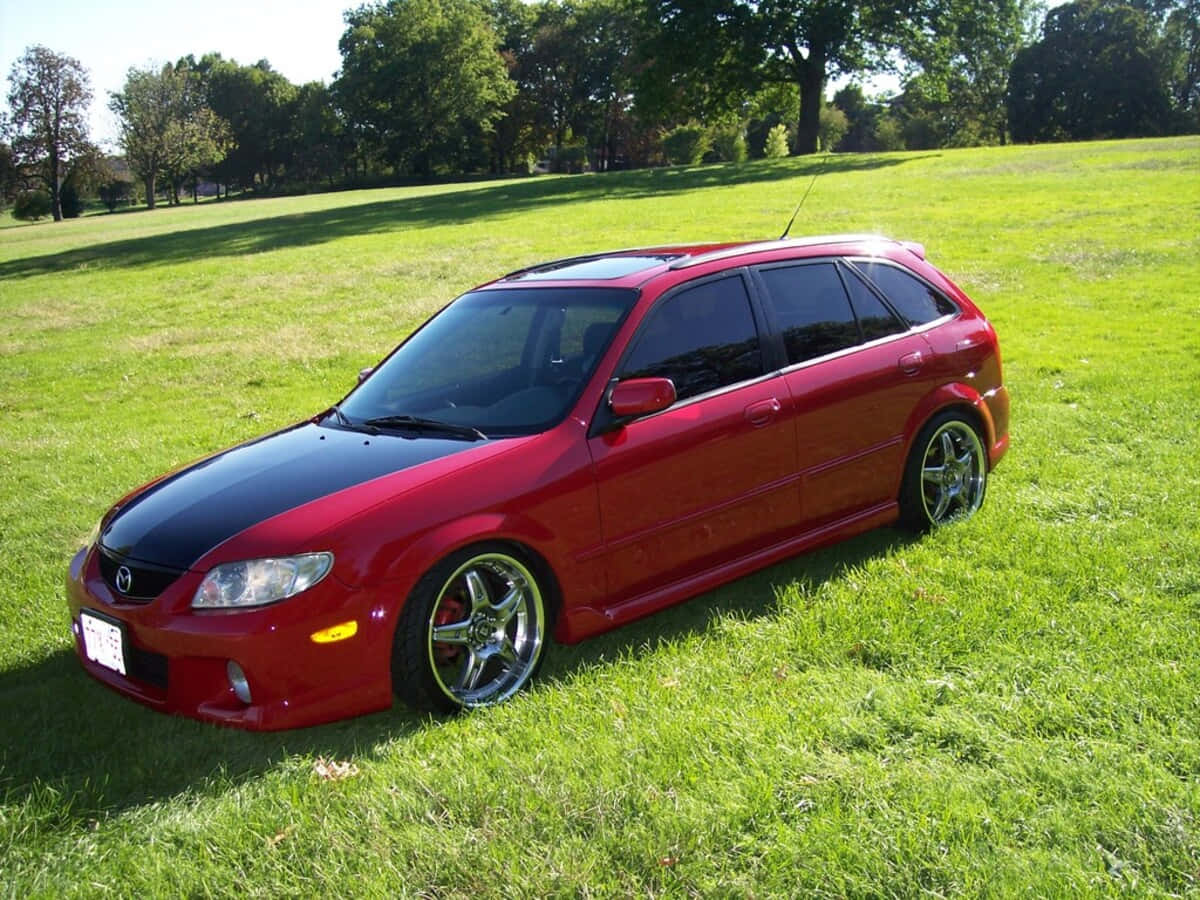 Mazda Protege In A Vibrant City Wallpaper