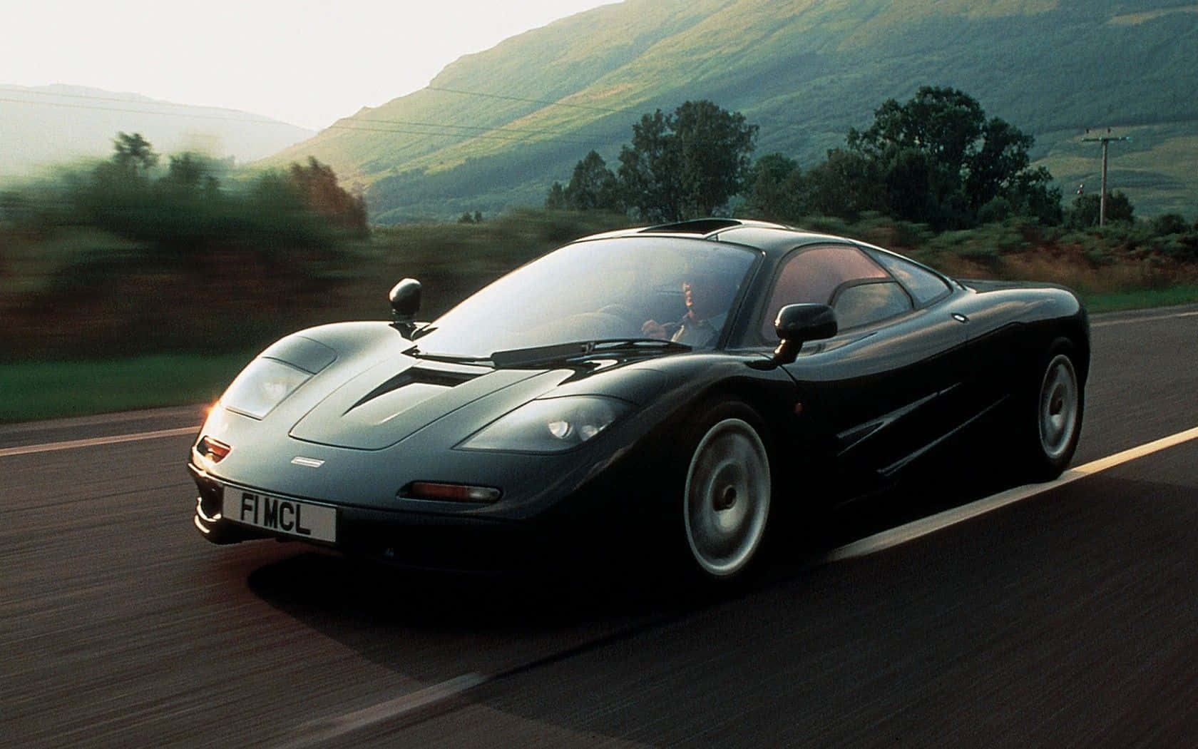 Mclaren F1 Speeding Down The Road Wallpaper