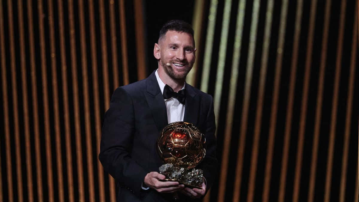 Messi Holding Ballond Or Award Wallpaper