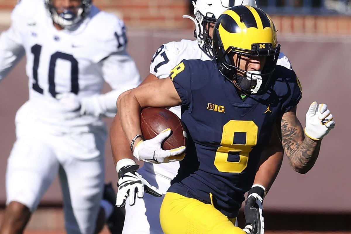 Michigan Football Player Running With Ball Wallpaper