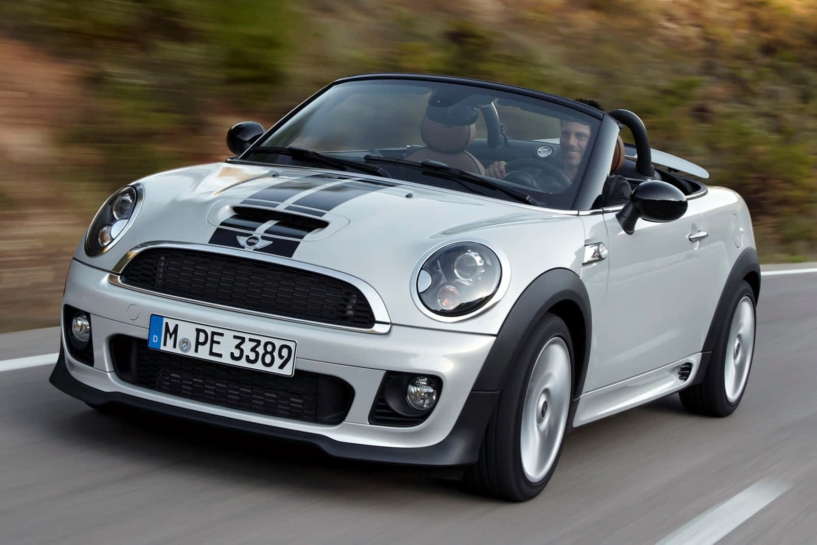 Mini Roadster Speedingon Highway Wallpaper