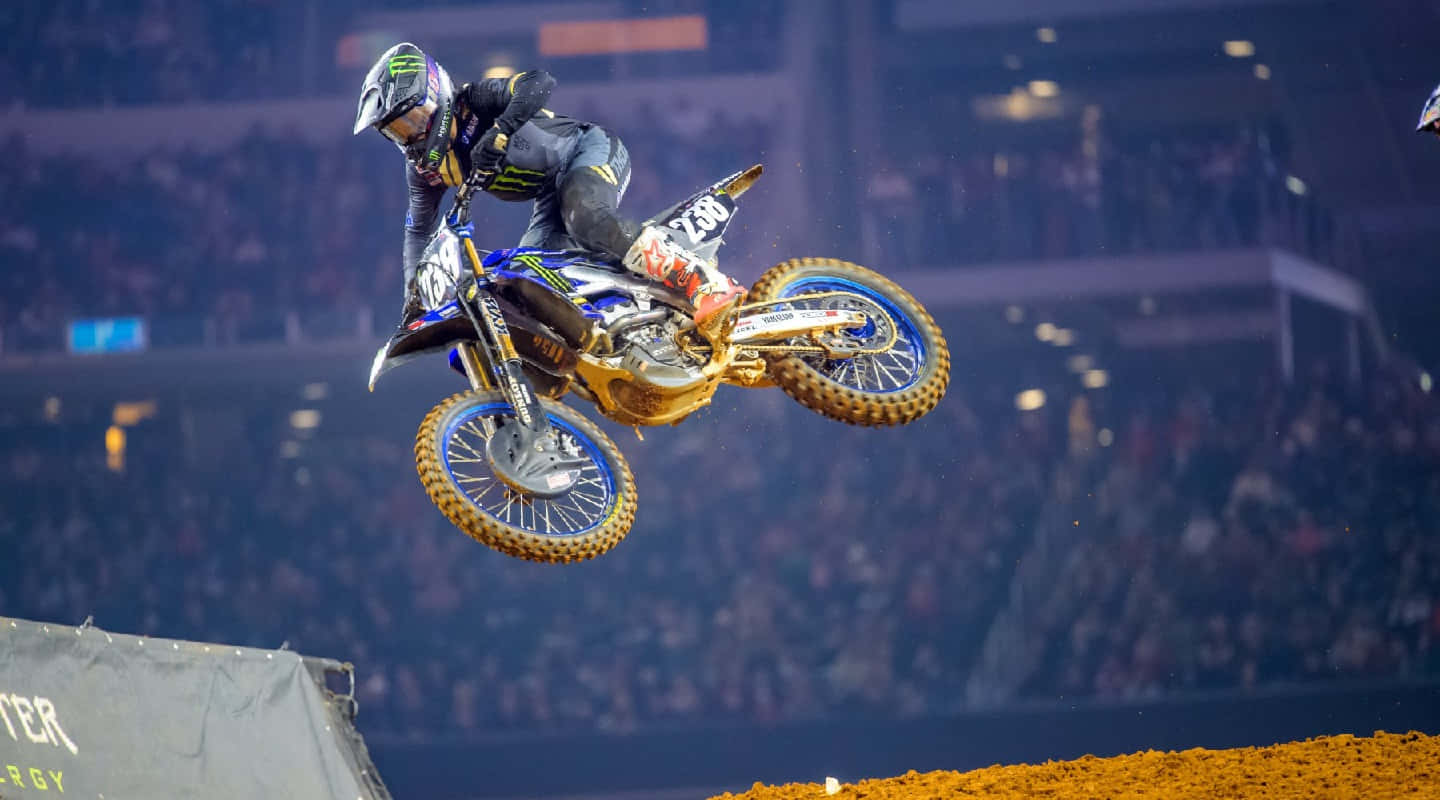 Motocross Athlete Midair Stunt Wallpaper