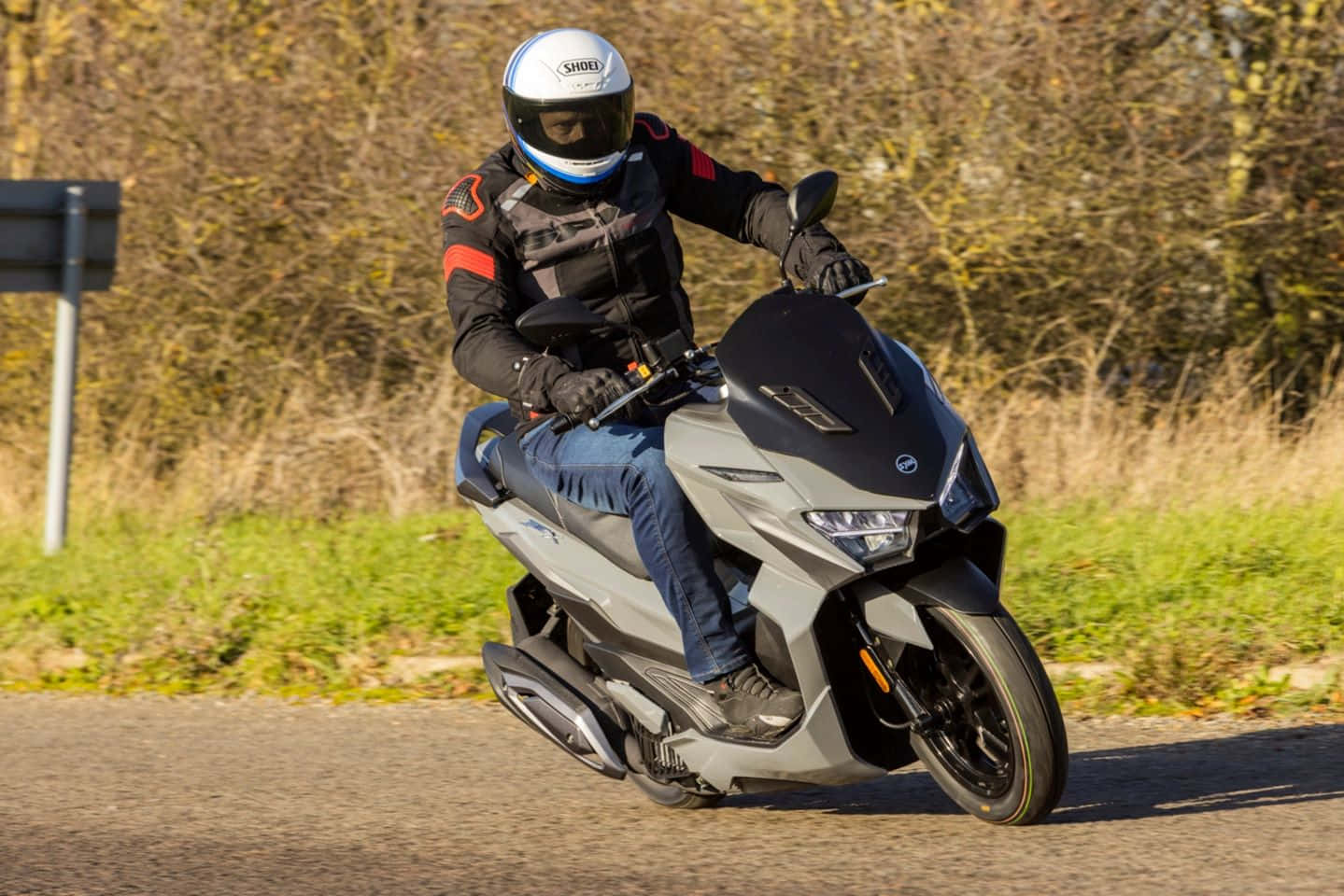 Motorcyclist Riding Scooter On Road Wallpaper