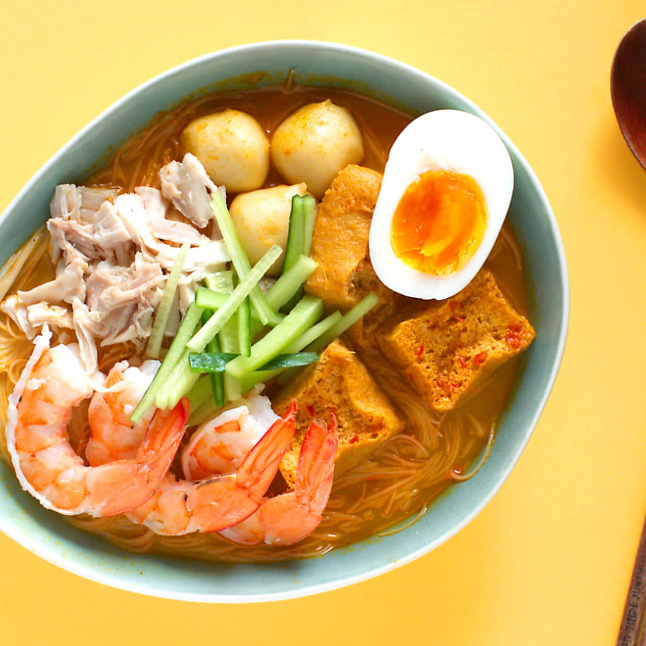 Mouthwatering Curry Laksa Served On A Bright Yellow Table Wallpaper