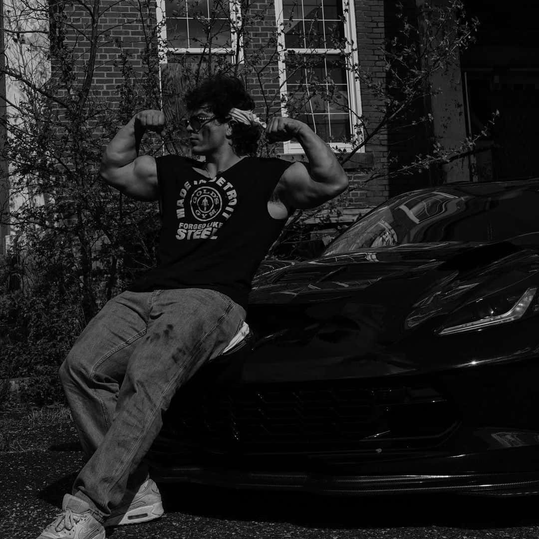 Muscular Man Flexingby Sports Car Wallpaper