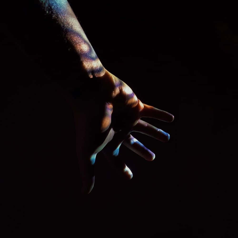 Mysterious Dark Hand Reaching Out From The Shadows Wallpaper