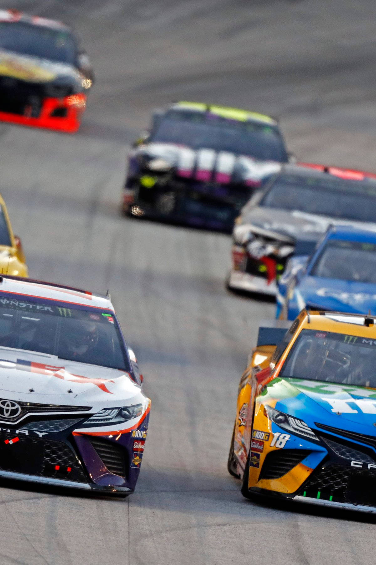 Nascar Legend Denny Hamlin Leading The Speed In Intense Racing Battle Wallpaper