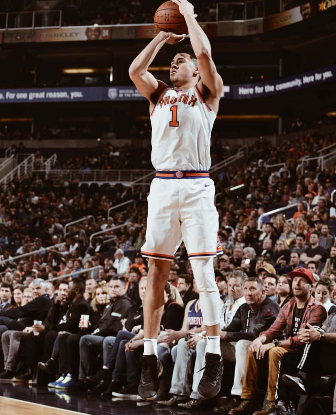 Nba All-star Devin Booker Showing Off His Iphone Wallpaper