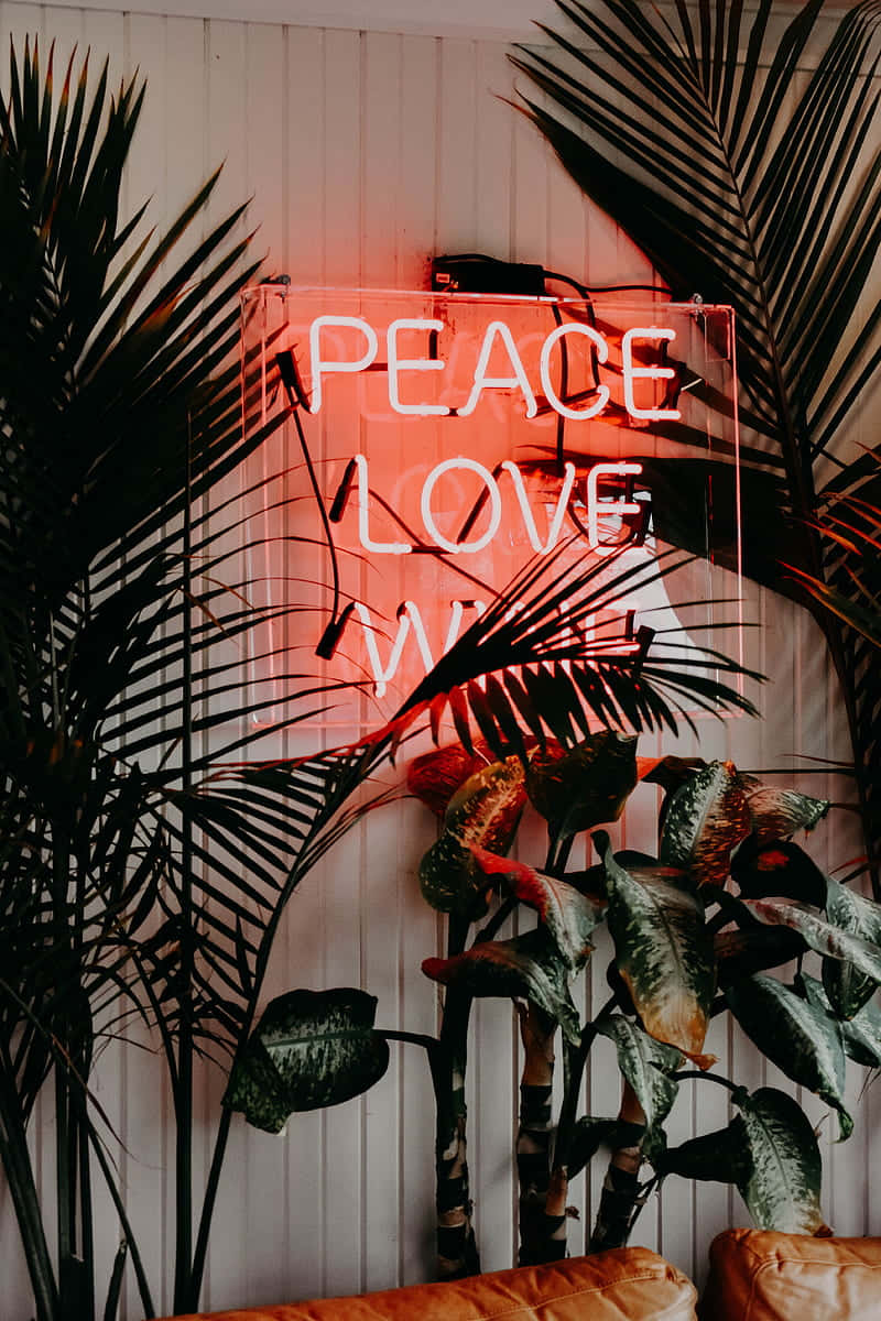 Neon Sign Peace Love Amongst Plants Wallpaper