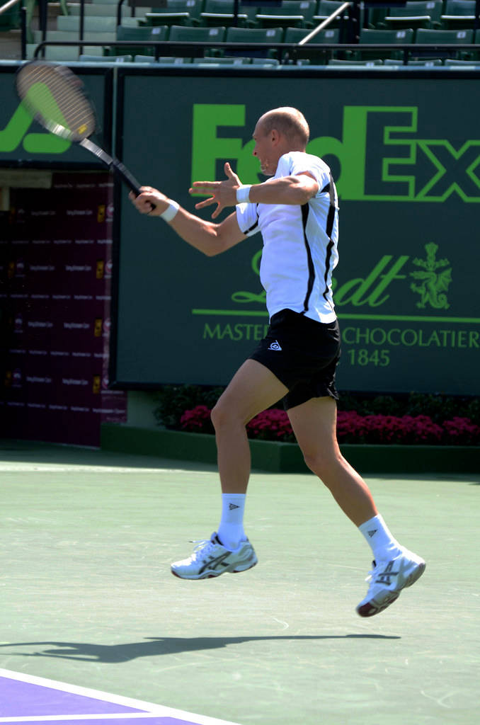 Nikolay Davydenko Executes A Sprinting Backhand On A Tennis Court Wallpaper