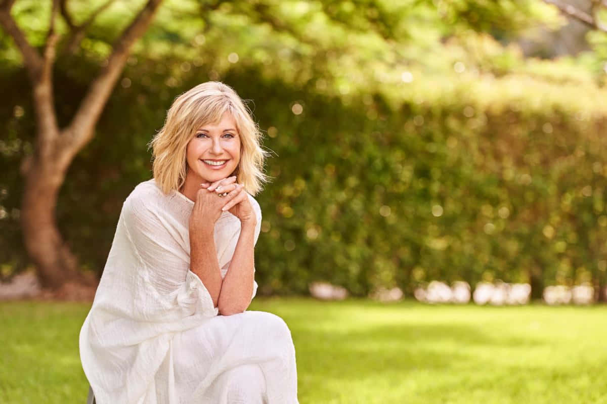 Olivia Newton-john Posing In A Stylish Outfit Wallpaper