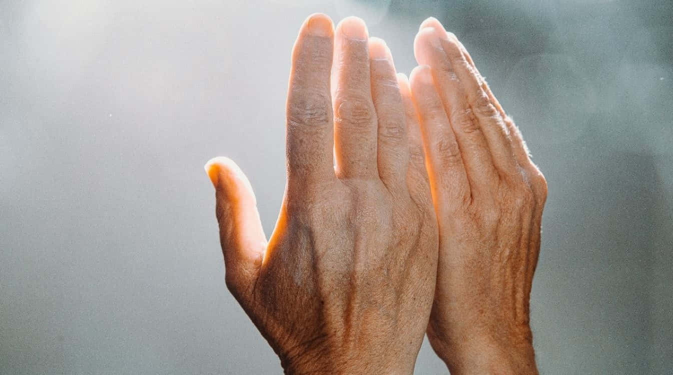 Peaceful Hands In Reiki Healing Energy Position Against Calming Blue Background Wallpaper