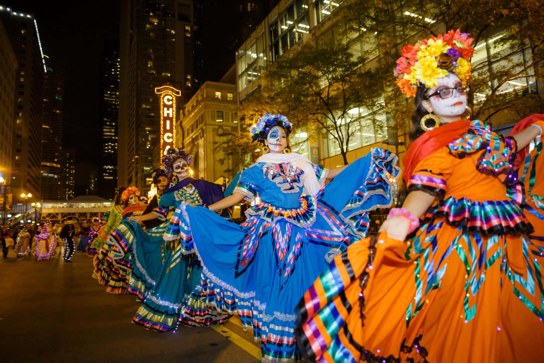 People Dressed In Spooky Costumes Parade Down A Cobblestone Road. Wallpaper