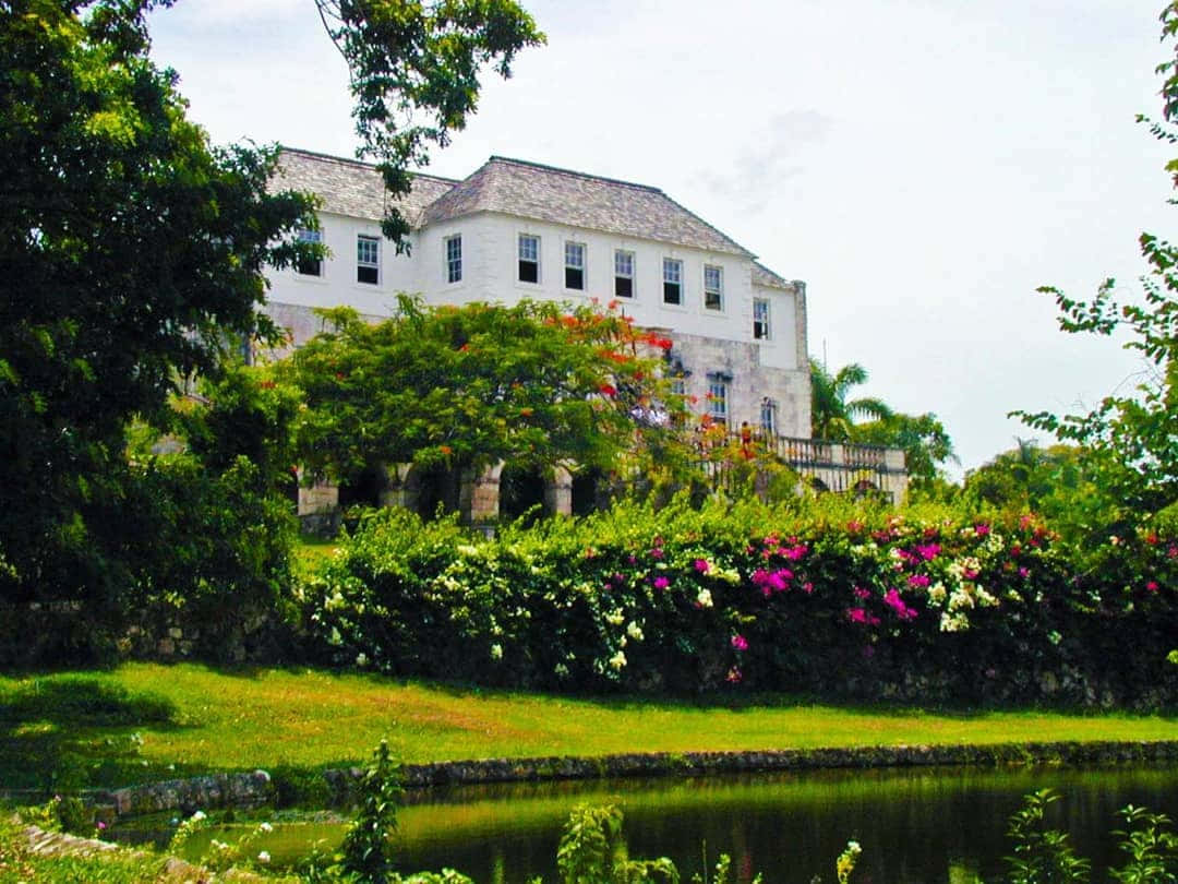 Picturesque View Of Rose Hall Great House Surrounded By Stunning Flora Wallpaper