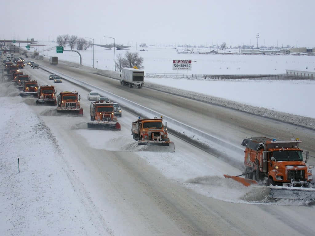 Powerful Snowplow Clearing The Road Of Snow Wallpaper