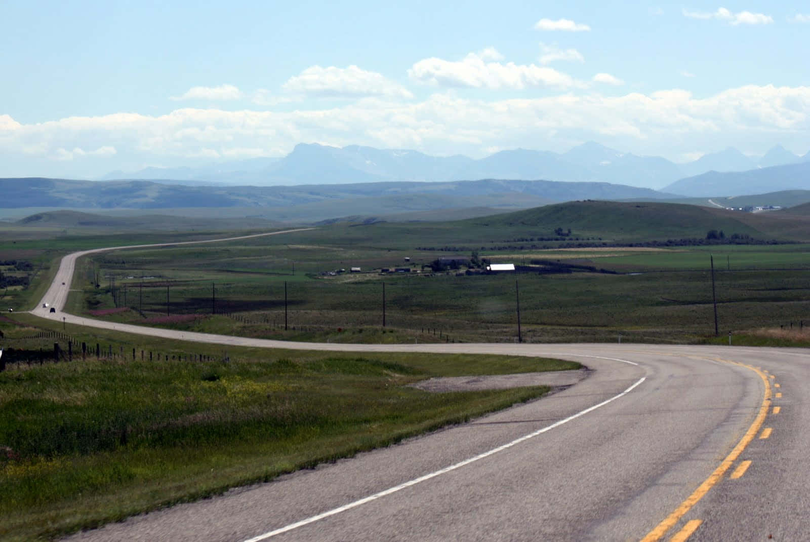 Prairie_ Road_ Leading_to_ Mountains Wallpaper