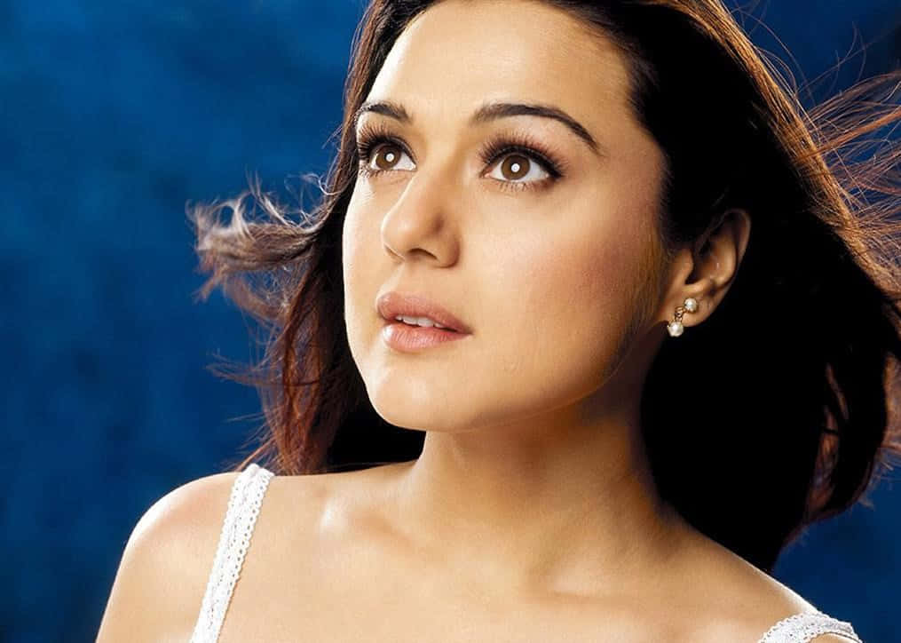 Preity Zinta Flowing Hair Blue Background Wallpaper