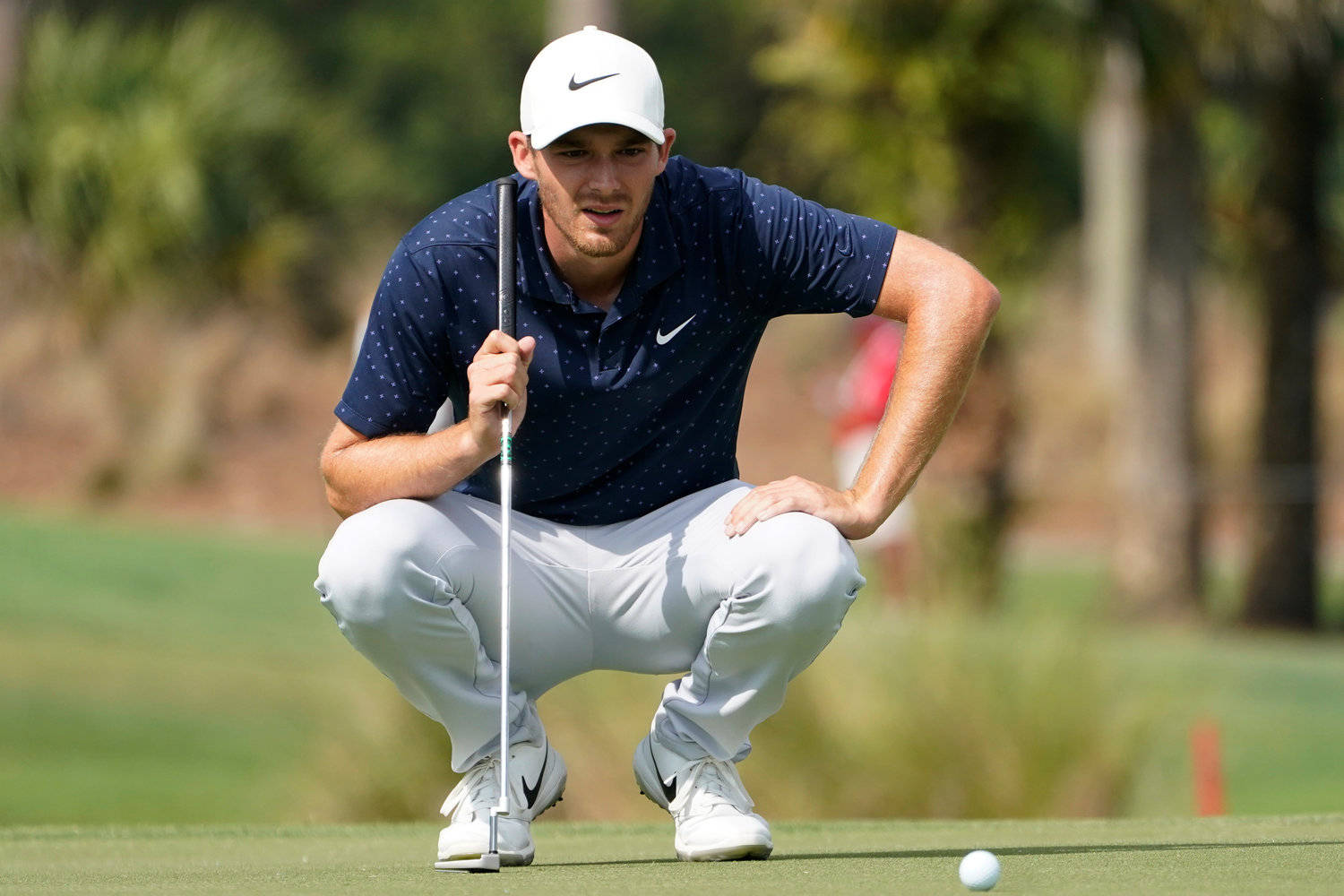 Pro Golfer Aaron Wise Strategizing On The Golf Field Wallpaper