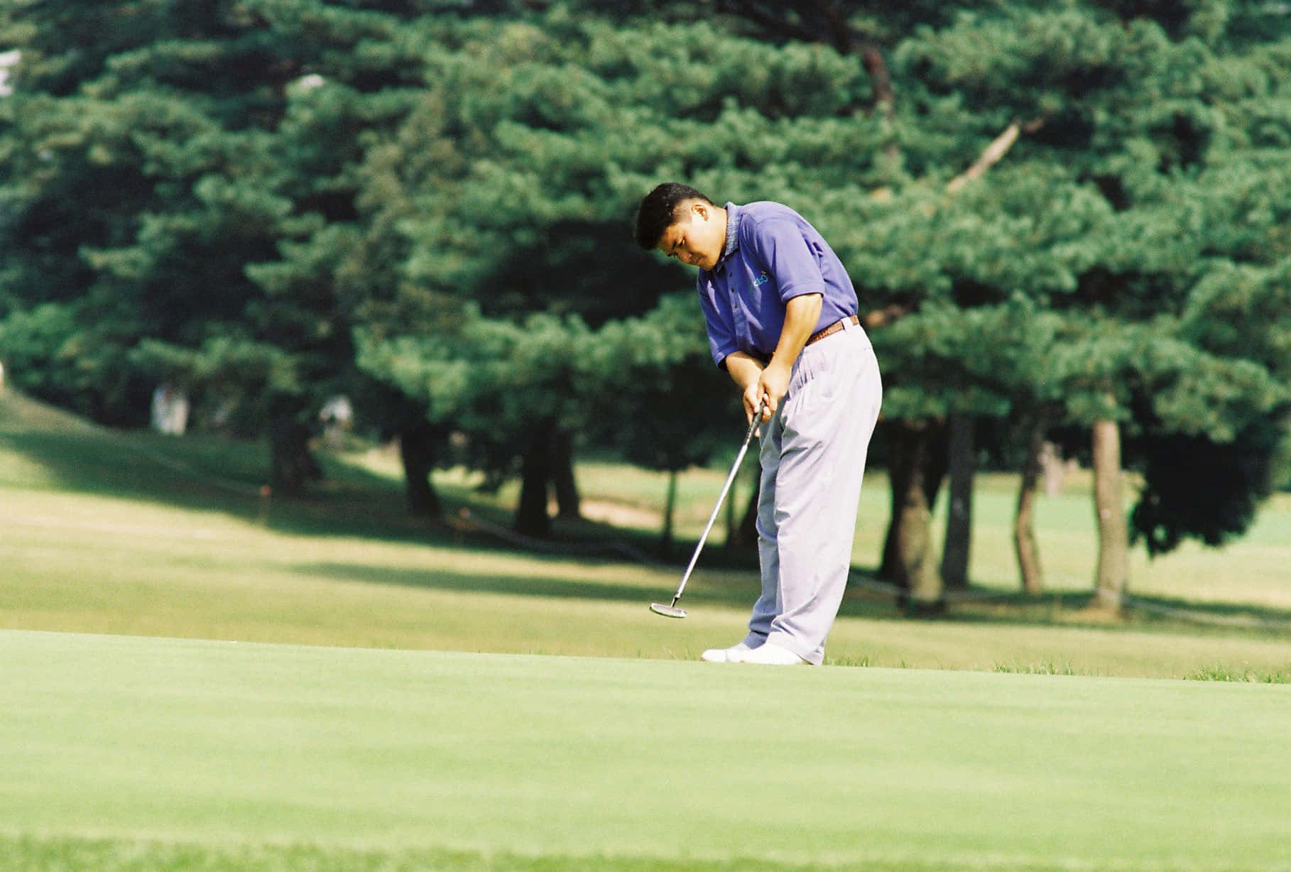 Pro Golfer Shigeki Maruyama In Steady Putting Pose Wallpaper