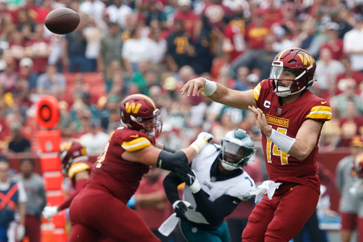 Quarterback Throwing Football During Game Wallpaper