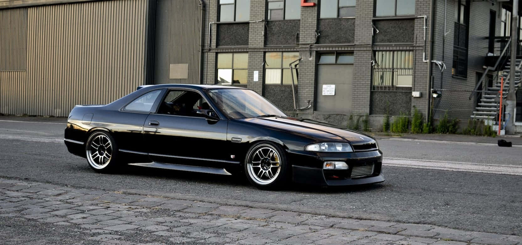 R33 Gtr Driving On City Street Wallpaper