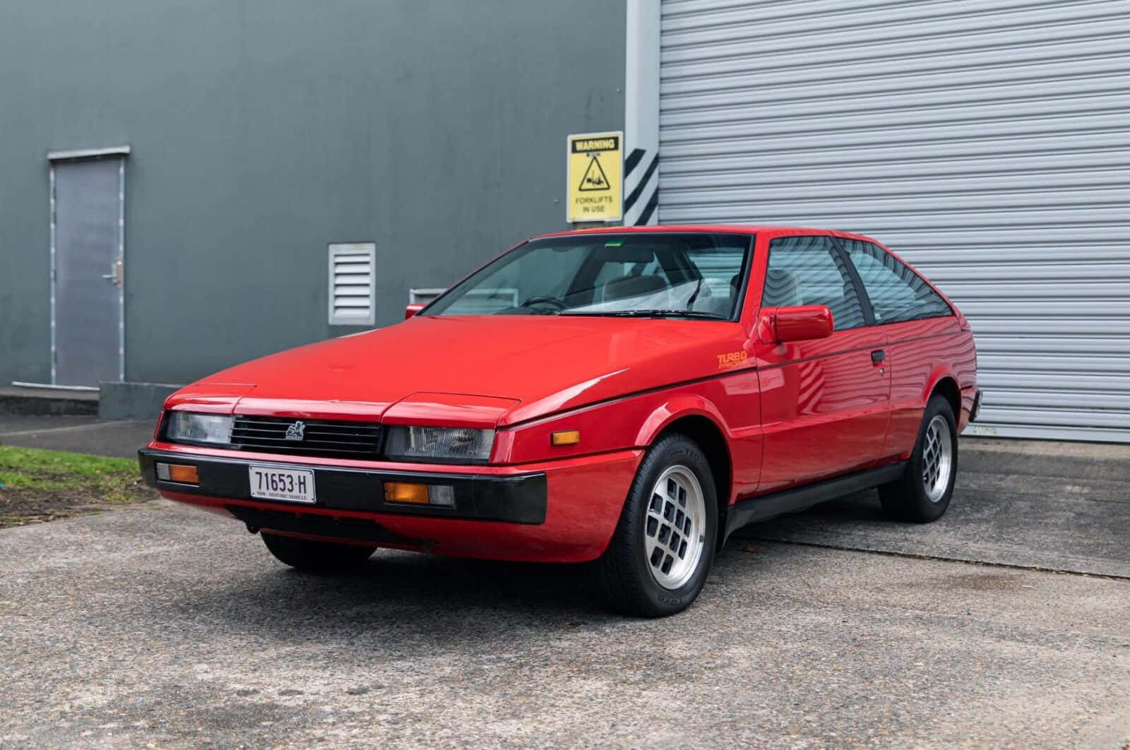 Red Isuzu Impulse Parked Wallpaper