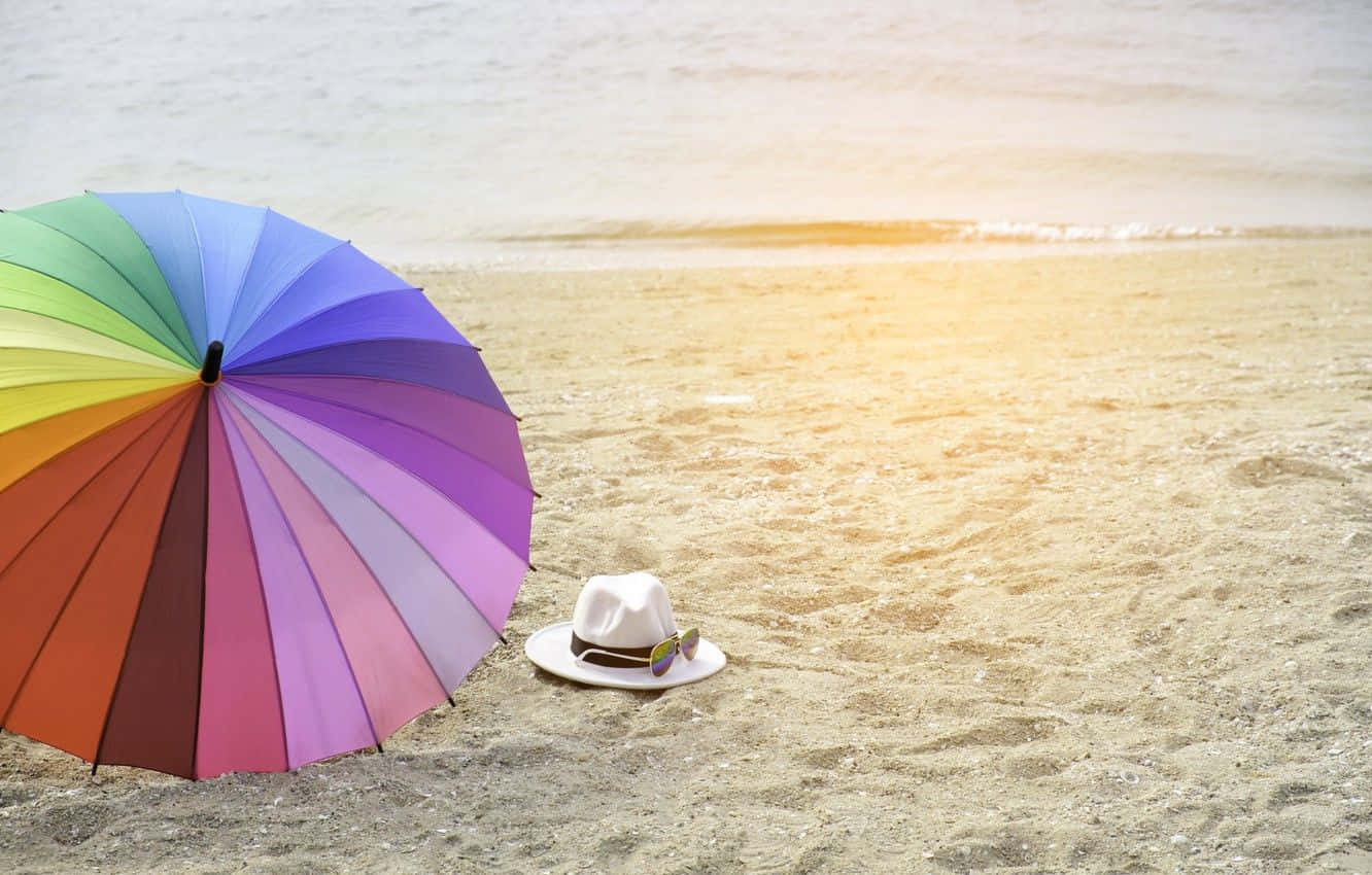 Relaxing Summer Days Under A Vibrant Beach Umbrella Wallpaper