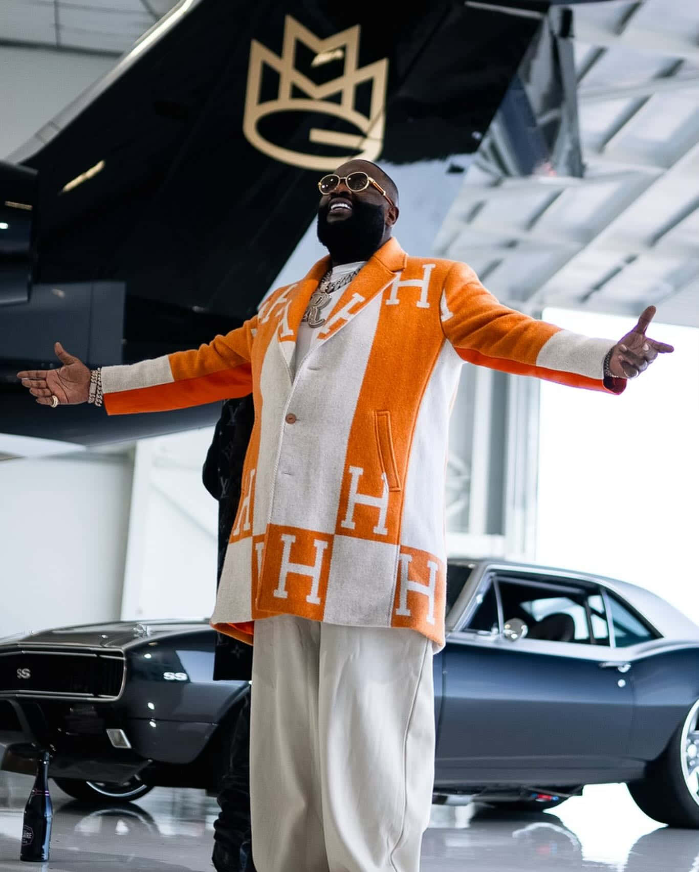 Rick Ross Orange Jacket Vintage Car Showroom Wallpaper