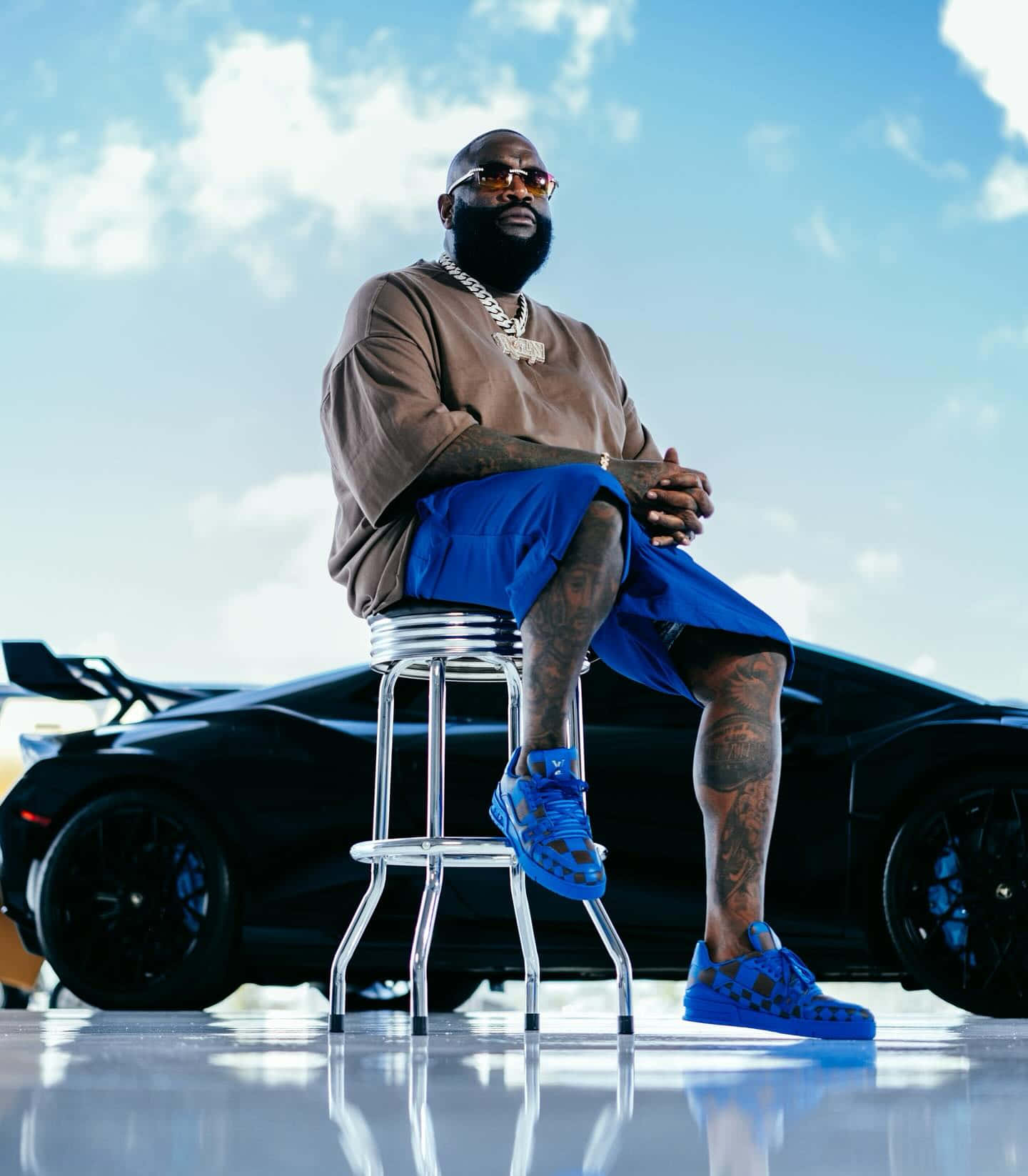 Rick Ross Sitting Beside Luxury Car Wallpaper