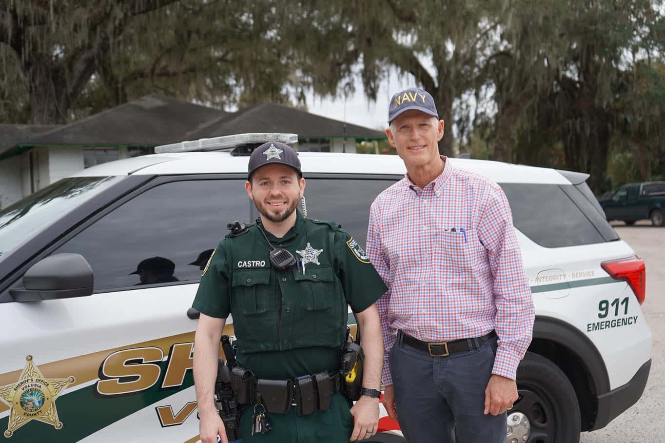 Rick Scott In Discussion With Law Enforcement Officer Wallpaper