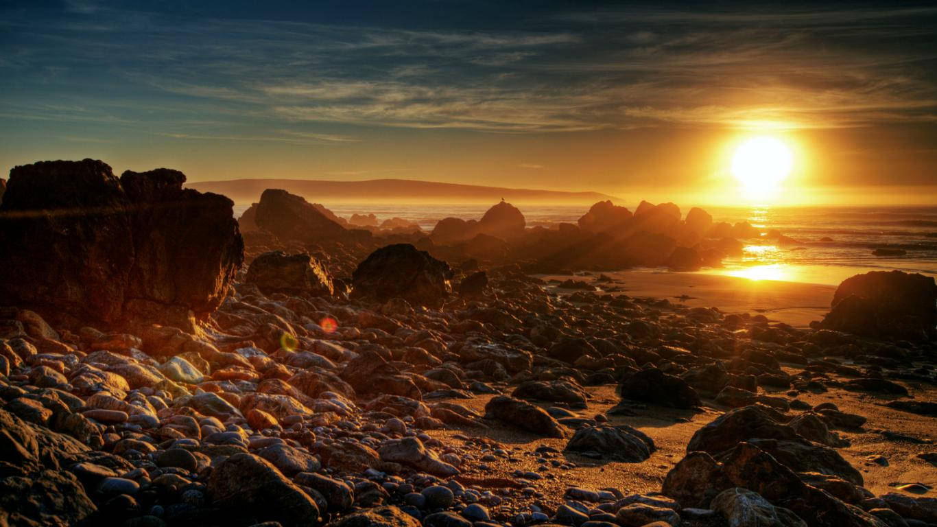 Rising Sun On Rocky Shore Wallpaper