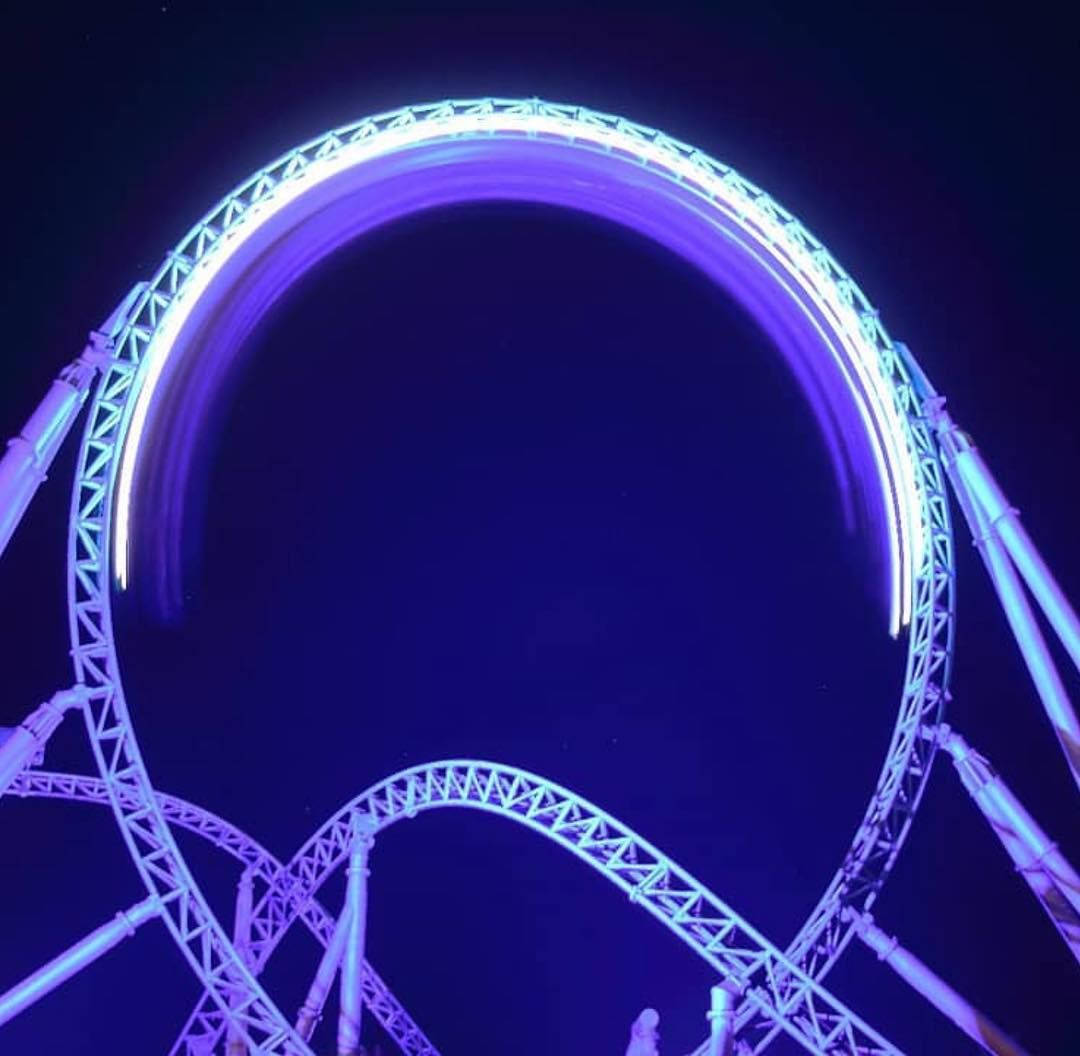 Roller Coaster In Glowing Purple Light Wallpaper