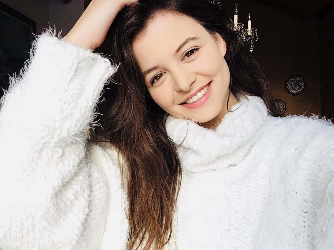 Sara Waisglass Smilingin White Sweater Wallpaper