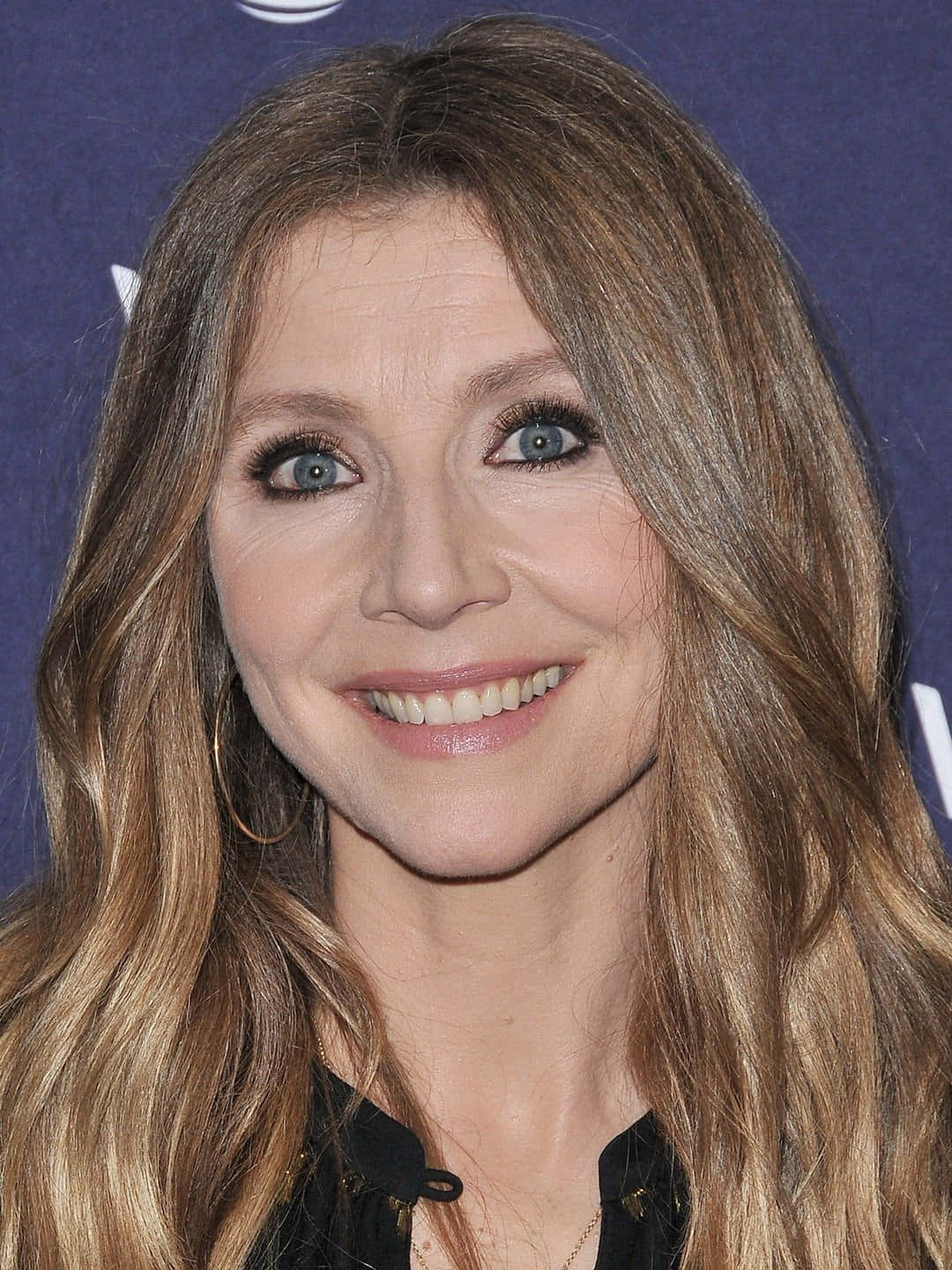 Sarah Chalke Posing Gracefully Against A Serene Backdrop Wallpaper