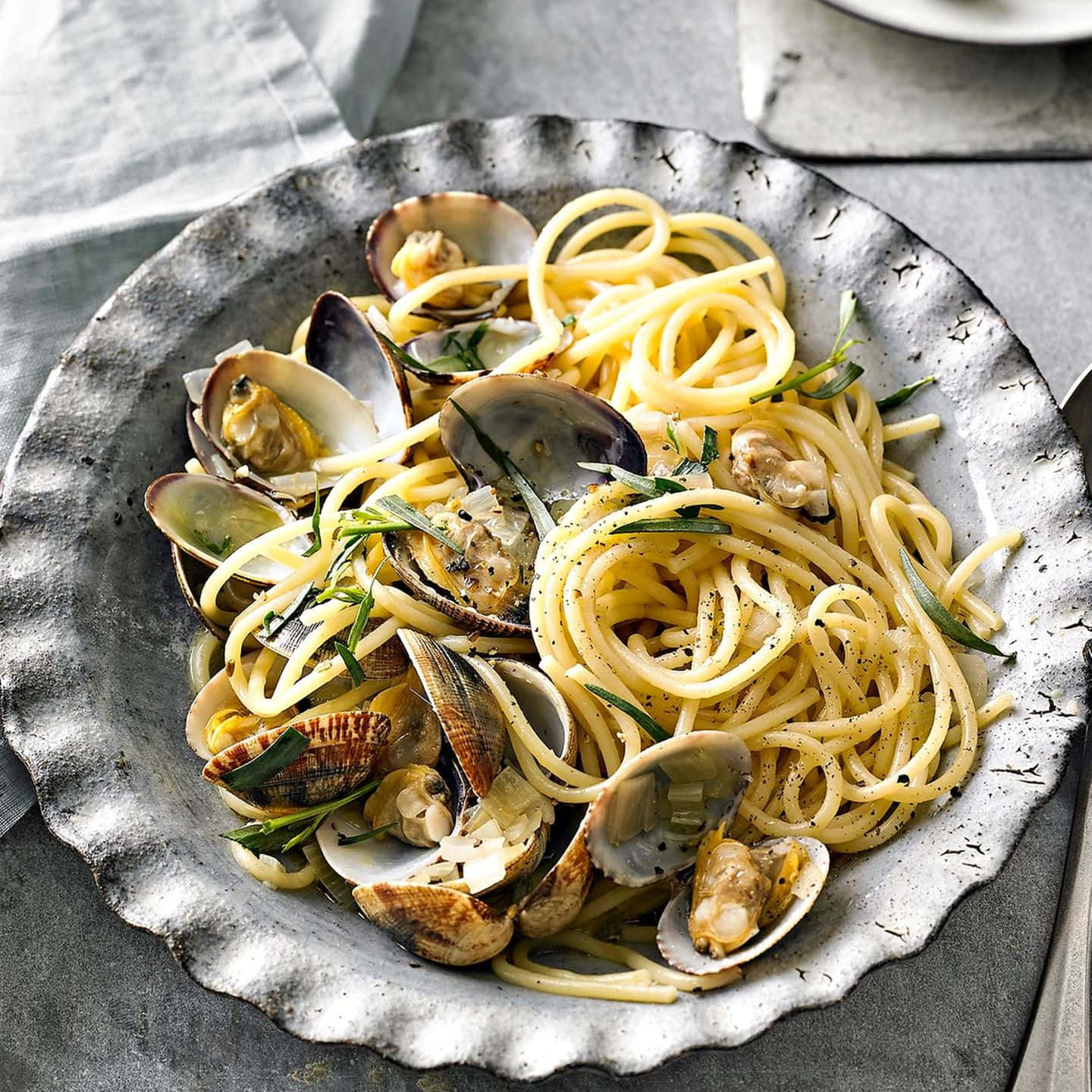 Savory Spaghetti Alla Vongole Served On A Rustic Plate Wallpaper