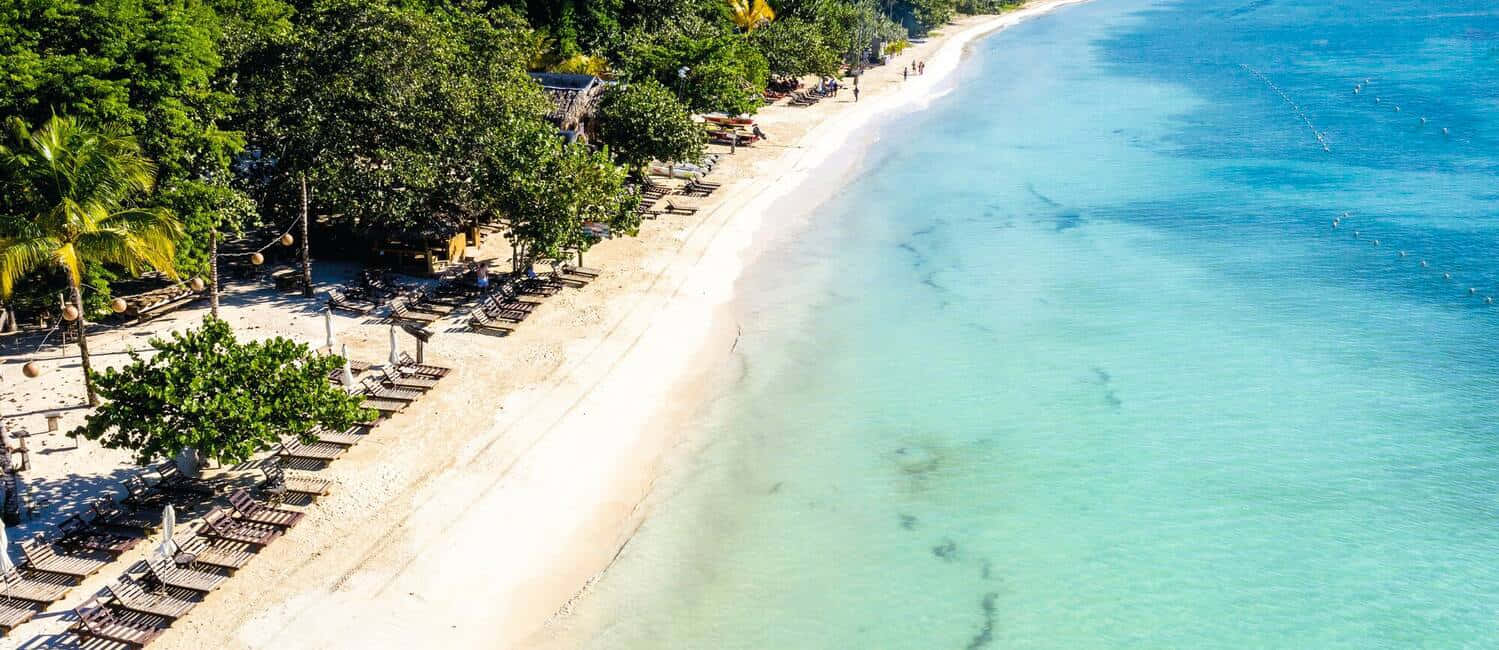 Scenic Jamaican Beach At Sunset Wallpaper