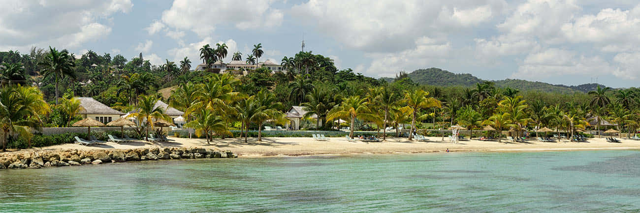 Serene Jamaican Beach At Sunset Wallpaper