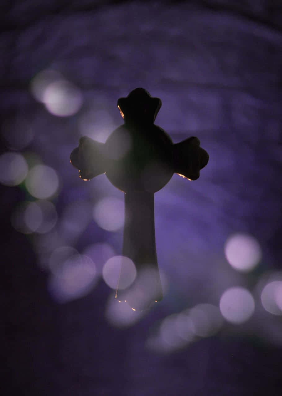 Silhouetted Cross Against Bokeh Lights Wallpaper