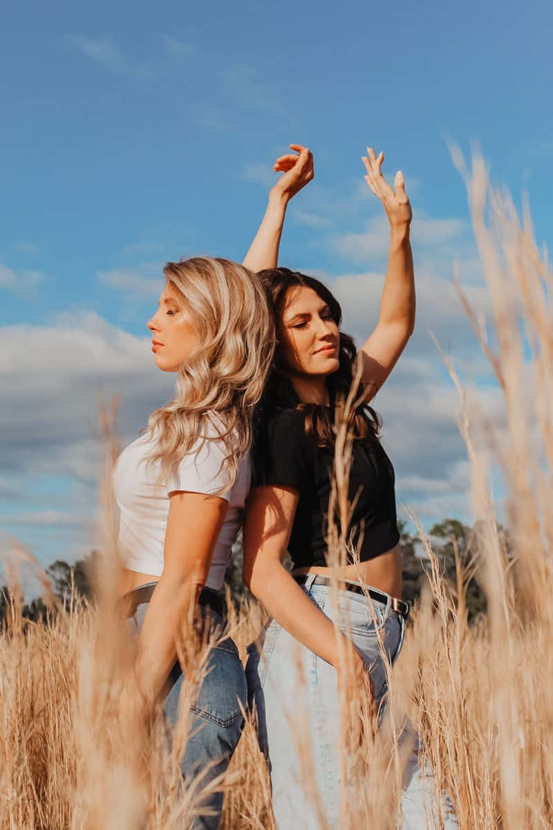 Sisters_ Embracing_in_ Sunny_ Field.jpg Wallpaper