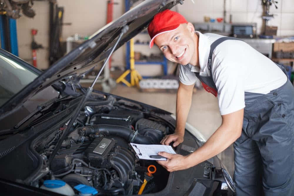 Skilled Mechanic Fixing A Car Engine Wallpaper