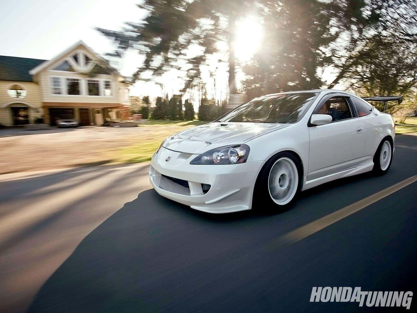 Sleek Acura Rsx Type-s In Motion On A Scenic Road Wallpaper