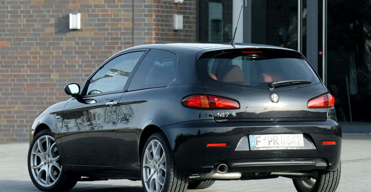 Sleek Alfa Romeo 147 On A Scenic Road Wallpaper