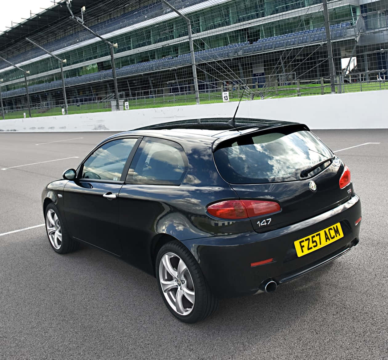 Sleek Alfa Romeo 147 Showcasing Its Elegant Design And Striking Presence In A Picturesque Setting. Wallpaper