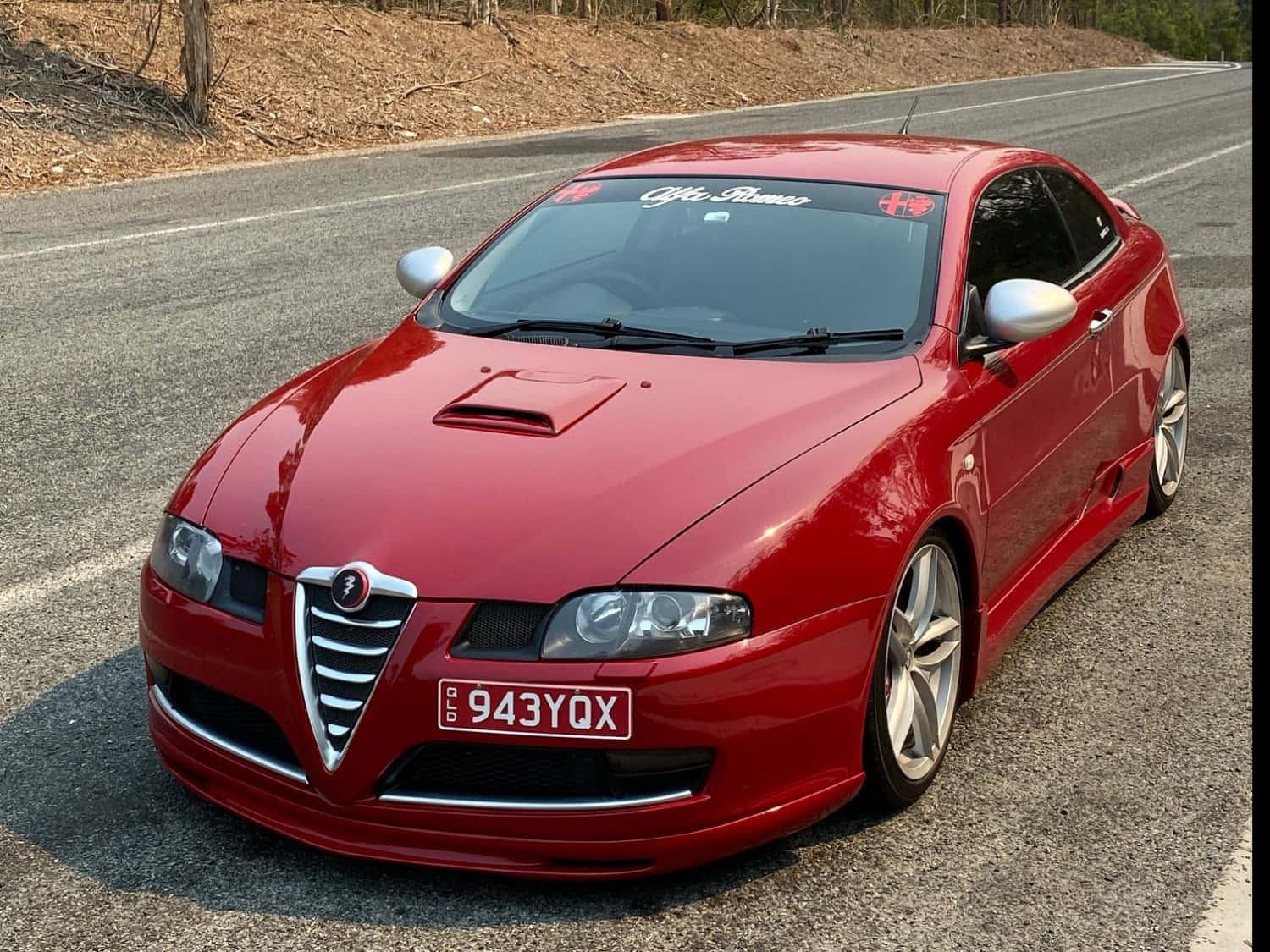 Sleek Alfa Romeo Gt In A Picturesque Outdoor Setting Wallpaper