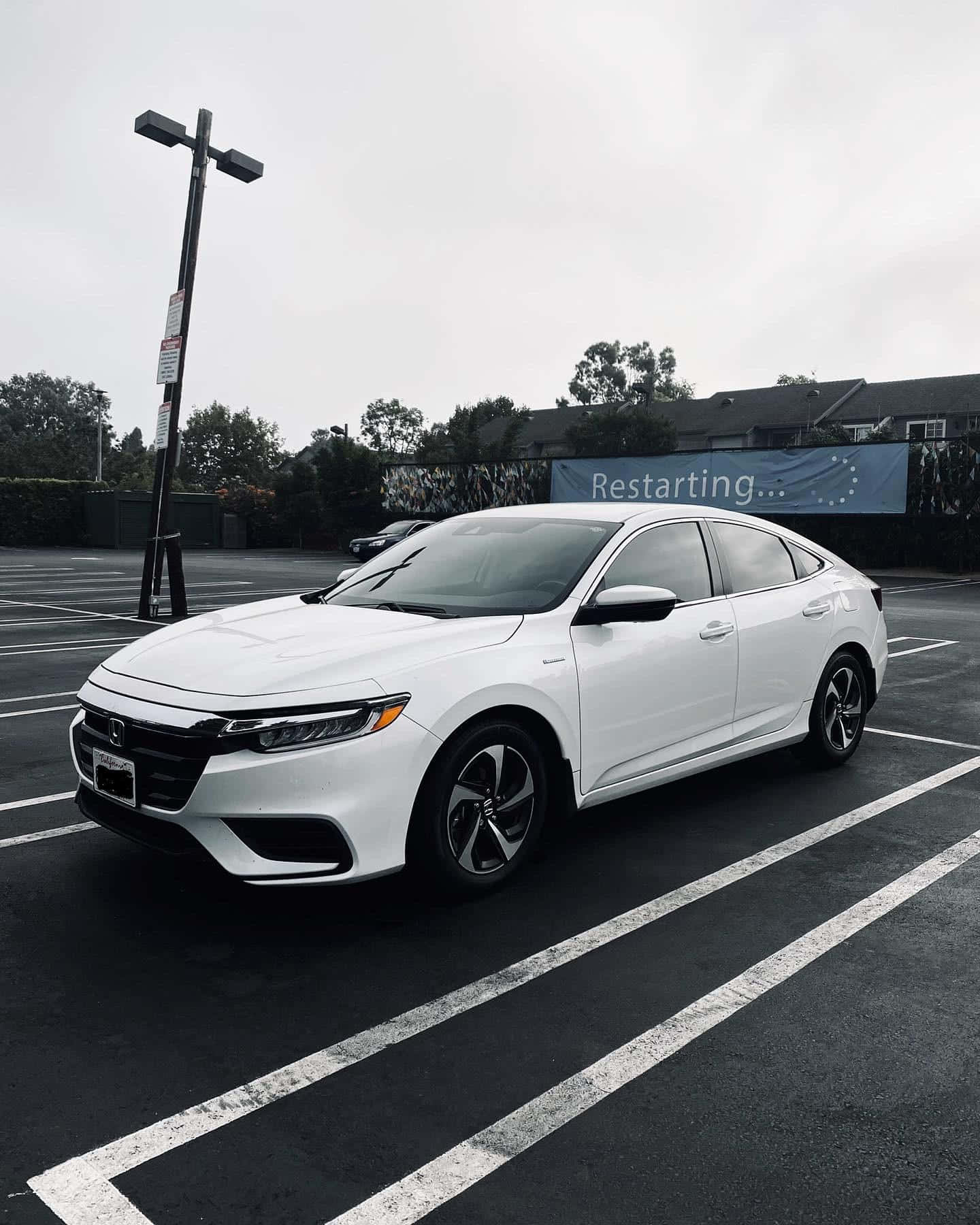 Sleek And Sophisticated Honda Insight On A Scenic Urban Road Wallpaper