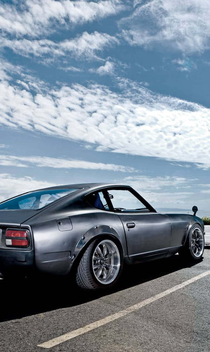 Sleek And Stylish Datsun Car On The Road Wallpaper