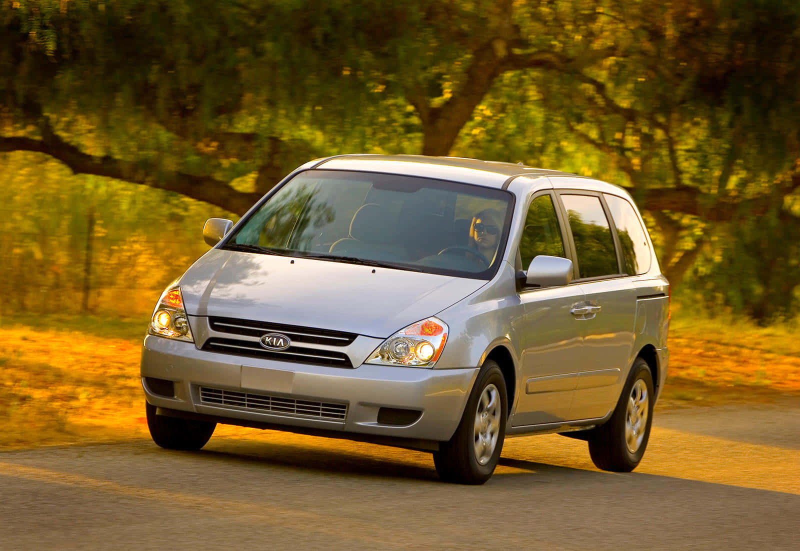 Sleek And Stylish Kia Sedona Minivan On The Road Wallpaper