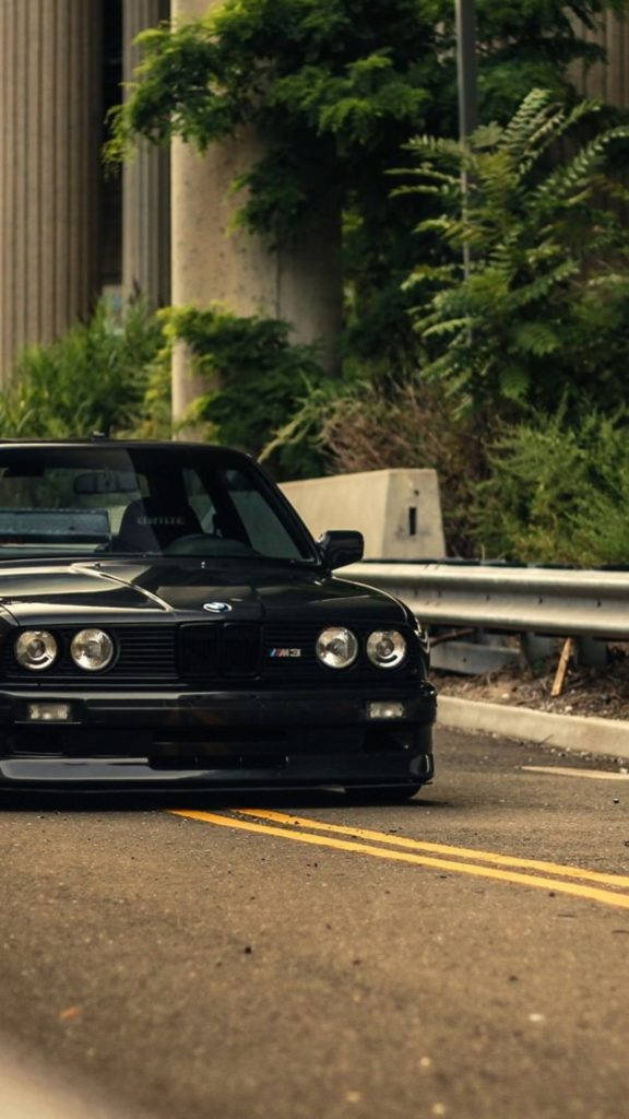 Sleek Black Bmw M3 Cruising The Highway. Wallpaper